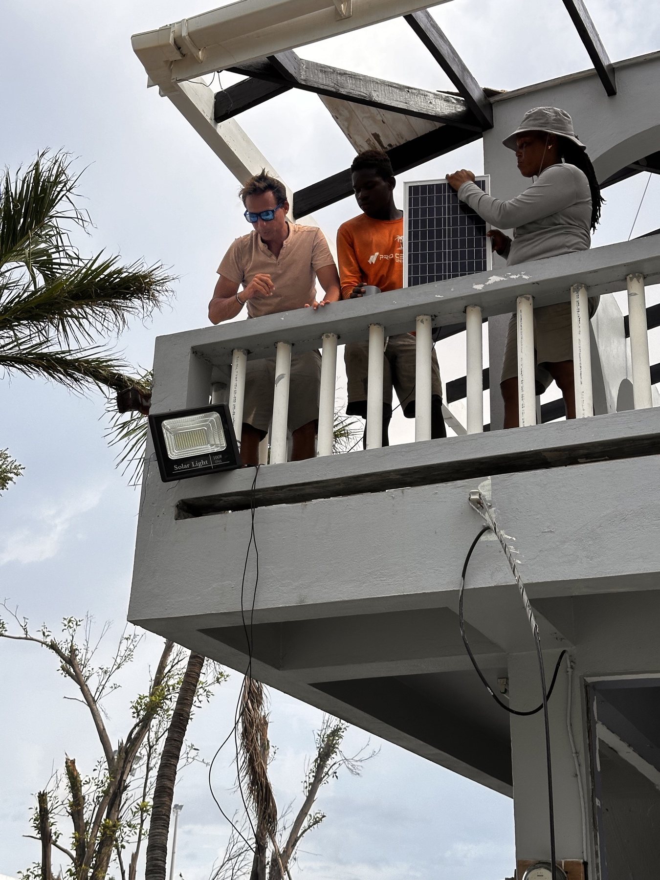 Jeremie and local team members installing a solar light after Hurricane Beryl