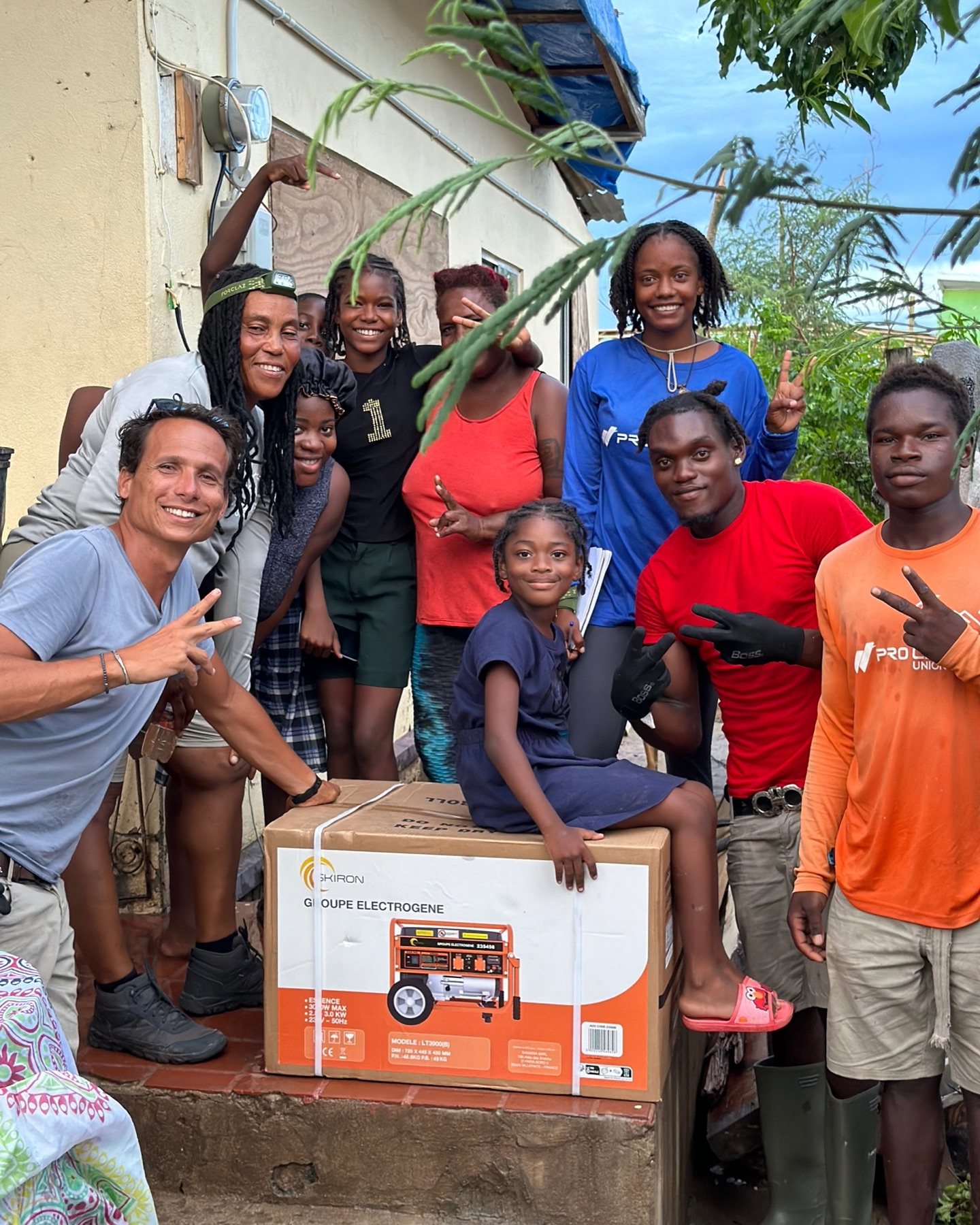 Relief team and residents with a generator delivery